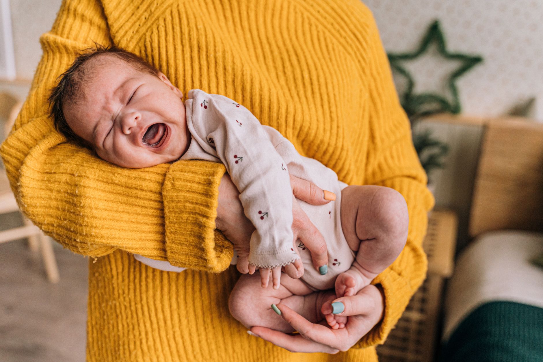 Mãe acolhe bebê chorando com cólica em bebê recém-nascido