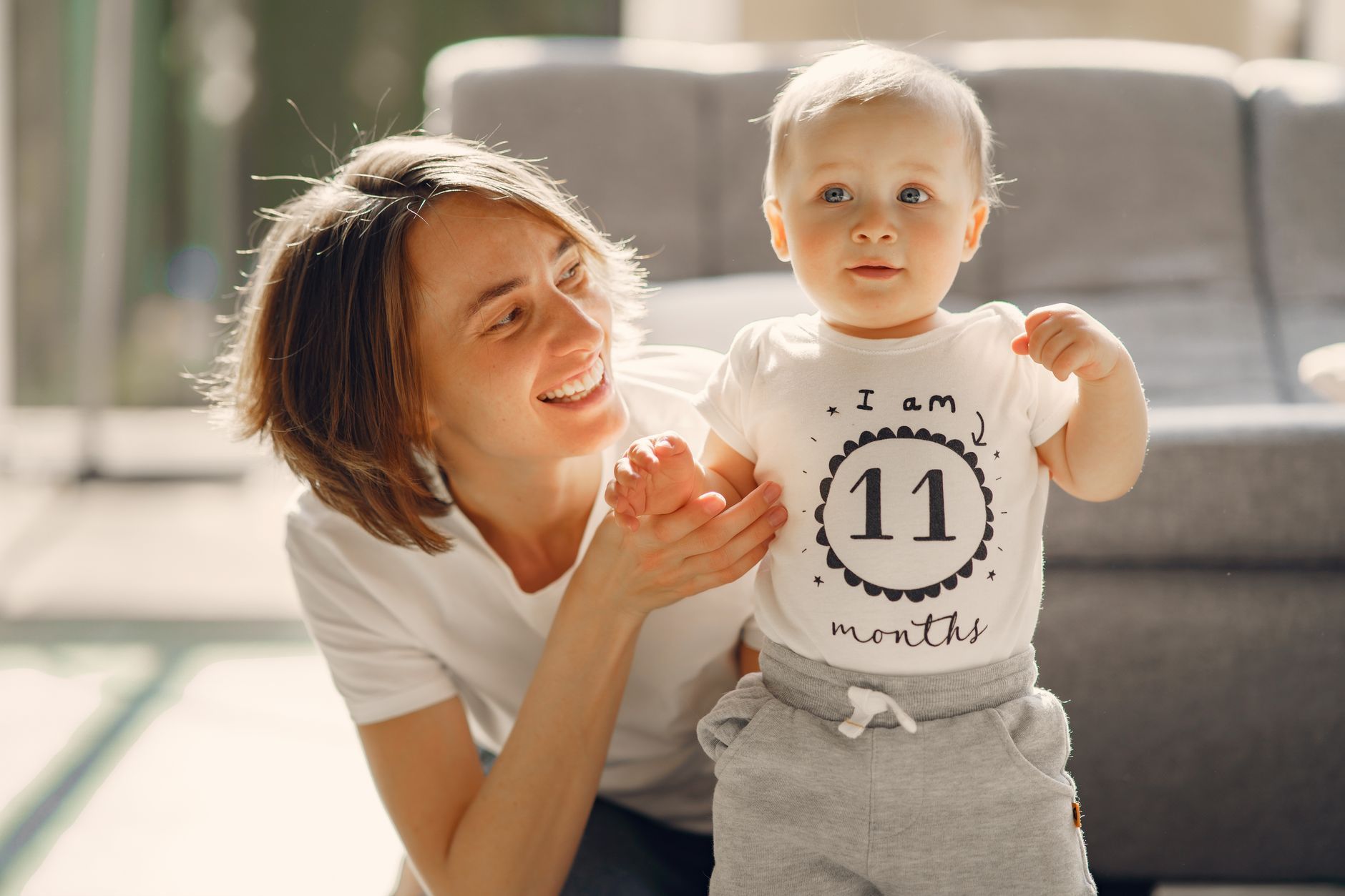 Bebê sorrindo durante tummy time no tapete, desenvolvimento do bebê mês a mês