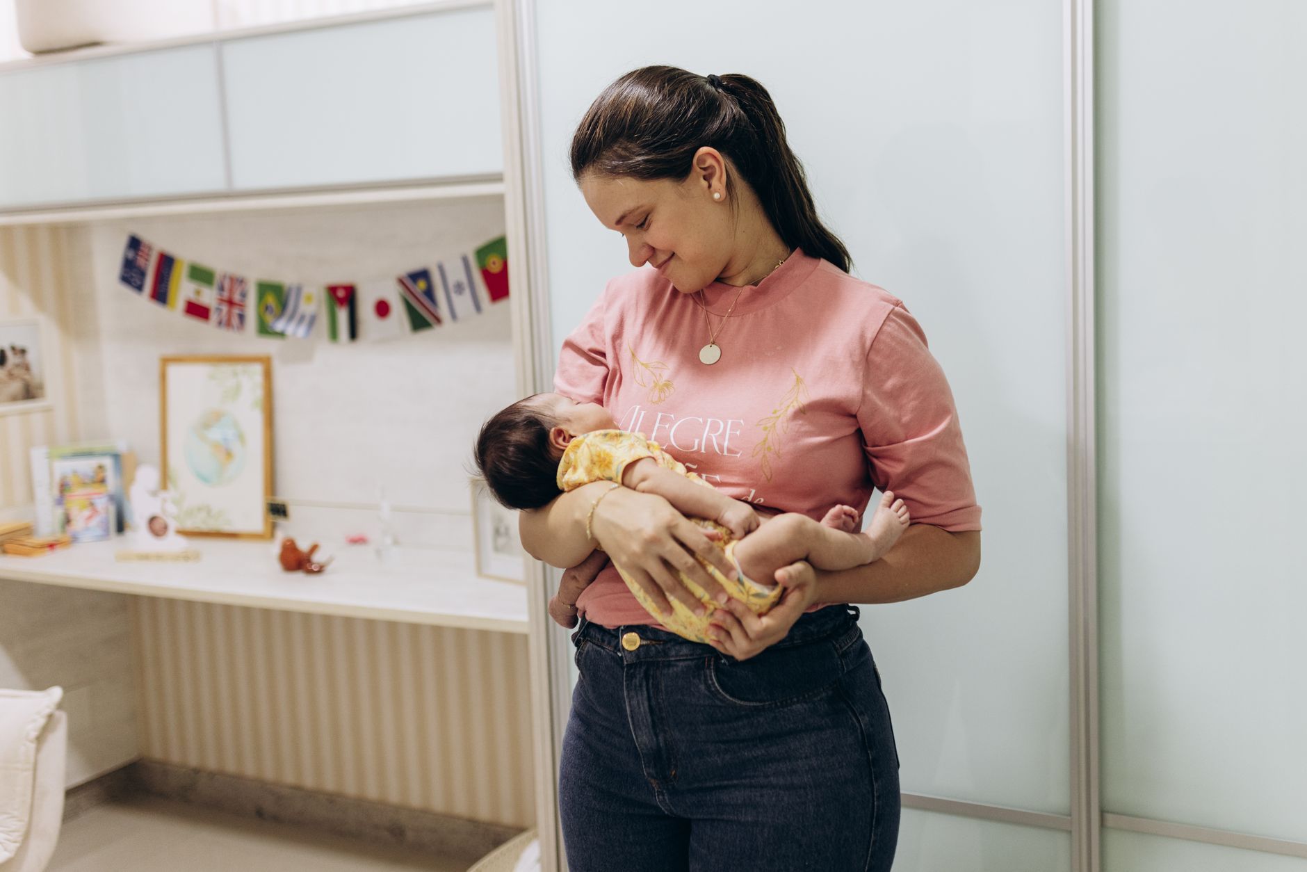 Bebê hidratando-se no colo da mãe com mamadeira, tema diarreia no bebe
